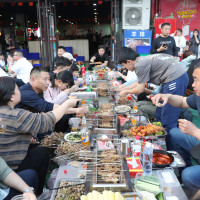 Customers eat skewers at Muyang Village Grill in Zibo, East China's Shandong province